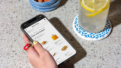 A close up shot of a person holding a mobile phone ordering from Joel's Place Click and Collect