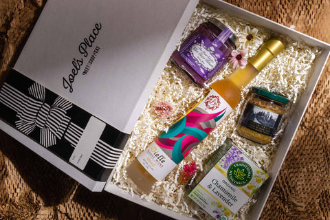 A flatlay image of a curated Mother’s Day gift box from Joel’s Place filled with gourmet and artisanal products.