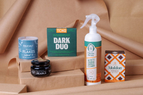 A photo of Joel's Place products in stacked in brown gift boxes and brown paper gift wrapping background