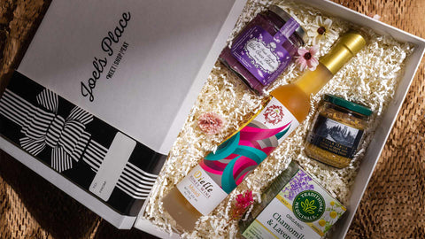 A flatlay image of a curated Mother’s Day gift box from Joel’s Place filled with gourmet and artisanal products.