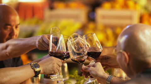 An image features an in-store news event at Joel's Place, with a group of people making a toast with glasses of red wine during the Sabor Español, a Spanish food and wine event.