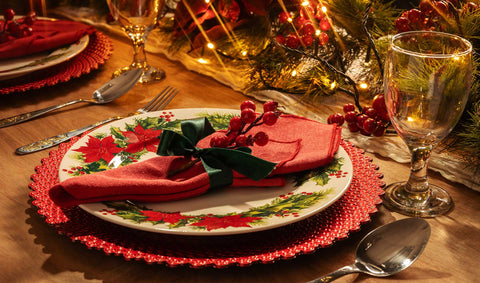 A formal dining table setting for Christmas with warm illumination from twinkling fairy lights