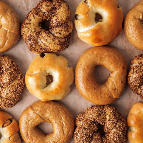 Different kinds of bagels neatly laid out on parchment paper