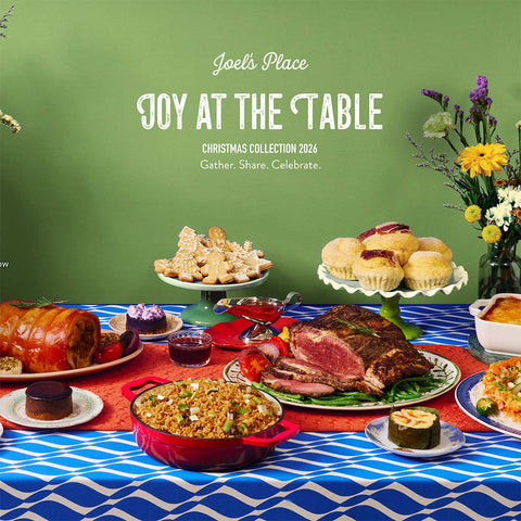 Joy at the Table Christmas 2026 Catalog cover featuring Joel's Place platters against a light green background and placed on a table with blue and white wave-patterned table cloth. 