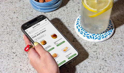 A girl browsing ready to eat meals on her smart phone via Click and Collect