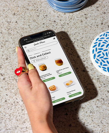 A girl browsing ready to eat meals on her smart phone via Click and Collect